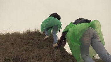 Yetişkin kız gezginler omuzlarında sırt çantalarıyla dağa tırmanırlar, hafta sonları ve tatillerde macera ve eğlence, arkadaşlarıyla turistik bir gezi.