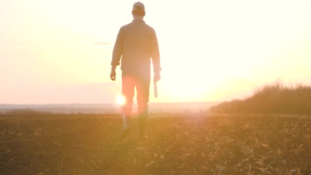 Agriculture. smart farming technology. farmer walk feet in boots with digital tablet walk on green field of grass at sunset. farmer walk agriculture concept — Stock Video