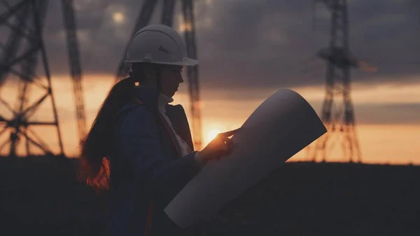 electrical silhouette worker engineer a working with digital tablet, power near tower with electricity. energy business technology industry concept. electrical engineer studying reading on tablet