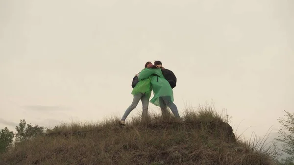 Een volwassen meisje beklimt een berg in de regengebieden met rugzakken, de vrouwelijke reizigers hebben een gezonde dag van rust samen, 4K, buitenleven, teamwork, een kampeertocht van mensen met rugzakken, langzame — Stockfoto