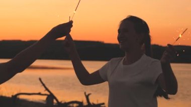 Havai fişekli mutlu kızlar gün batımında gökyüzünde dans edip gülüyorlar. Gençler güneşin doğuşunu güzel ışıklarla selamlıyor. Kız arkadaşlar seyahat eder. Tatillerde dinlenin. Doğum gününü neşeyle kutluyorsun.