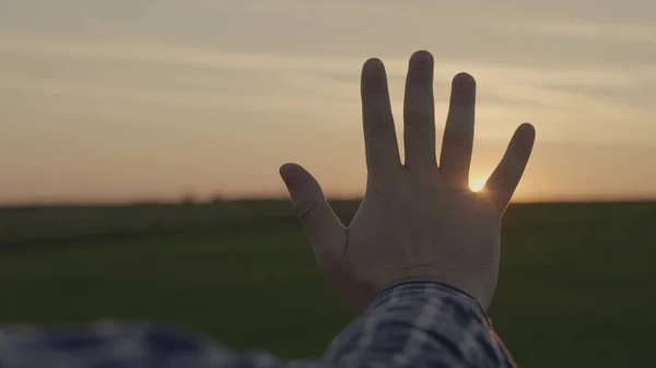 Gelukkige mensenhand bij zonsondergang. Zonsondergang tussen de handen van een man. Gelukkige man met dromerig strekt zijn hand uit naar de zon. Droomhand naar de zon. gelukkig familieconcept — Stockfoto