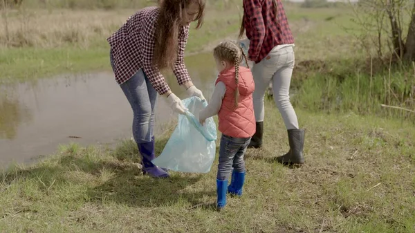 The little kid collects garbage in a volunteer team on environmental issues, clean the land of garbage, collect waste thrown out in resting places, habitat in danger