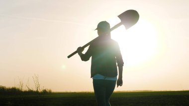 Yetişkin bir çiftçi kız, gün batımında omuzunda kürekle gökyüzünde yürür. Şafakta tarlada çalışan bir iş kadını tarlada çalışır. Bir adam yere damlatır ve tohum eker.