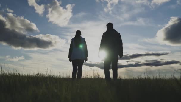 Silhueta de agricultores no campo ao pôr do sol uniu as mãos, unindo agrônomos, vivendo no campo, trabalhando na terra na época de plantio e colheita, trabalho em equipe — Vídeo de Stock