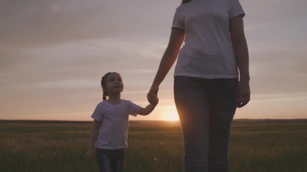 Malé dítě drží ruku matky při západu slunce, mateřská láska a péče o svou dceru, dotknout se snu matky, koncept šťastného rodinného života, dítě se dotýká rodiče s rukou — Stock video