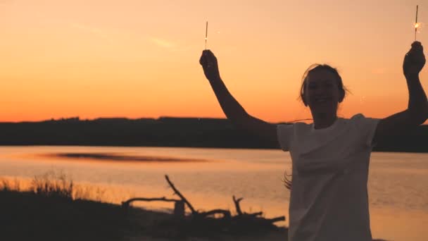 Gelukkige meisjes steken sterren in brand bij zonsondergang in de lucht en lachen. Jongeren begroeten de zonsopgang met prachtig licht. Vriendinnen reizen. Rust tijdens de feestdagen. Je verjaardag vieren met plezier — Stockvideo