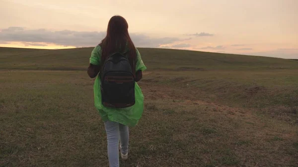 快乐活泼的嬉皮士女孩背着背包在美丽的落日下在美丽的山谷里旅行，千禧年的女人在绿地里，徒步旅行，远足，周末户外娱乐活动 — 图库照片