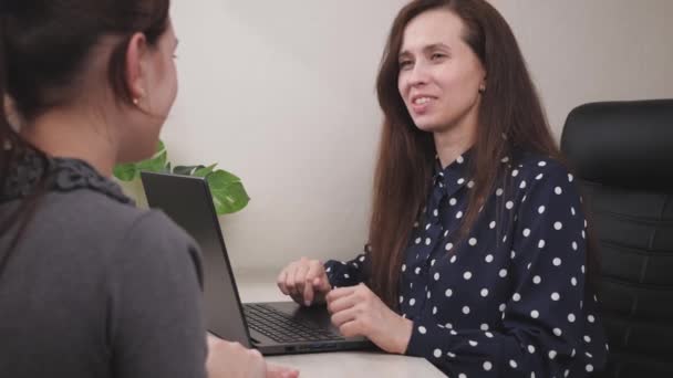 Hand schudden met elkaar, bedienend personeel aan het werk met een klant, werken op een laptop in een bedrijf, handen schudden, een vriendelijke zakenvrouw in een kantoor achter een computer, teamwork — Stockvideo