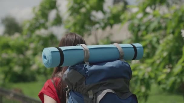 Fille voyageur millénial avec sac à dos bleu et tapis de yoga voyages, explorer les attractions locales, femme active à la recherche d'aventure, vie heureuse, vacances de randonnée, profiter de la nature en plein air, ralenti — Video