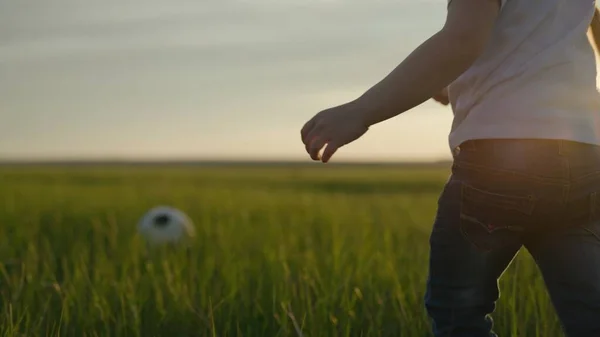 Kleine kind speelt voetbal met een voetbal op het groene veld van het stadion bij zonsondergang, professionele voetbalteam training, kind dynamische actieve training, fan leven, leren om een doel te scoren — Stockfoto