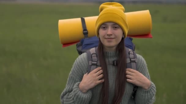 Gelukkig actief hipster meisje met rugzak op haar rug reizen in prachtige vallei, duizendjarige vrouw op groen veld, wandelen reizen, wandelpad, outdoor recreatie weekend — Stockvideo