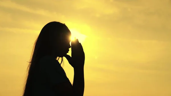 A Muslim girl prays in the glare of the sun in the sky, a little teenager believes in goodness, ask for forgiveness from heaven, educate a kid in religion, ask for good things in life, child dream of — Stock Photo, Image