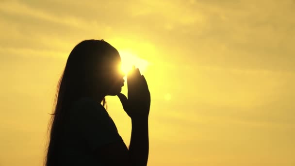 Una ragazza musulmana prega nel bagliore del sole nel cielo, una piccola adolescente crede nella bontà, chiede perdono dal cielo, educare un bambino alla religione, chiedere cose buone nella vita, sognare bambini di — Video Stock