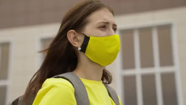 Μαθήτρια κοπέλα με μάσκα με σακίδιο μιλάει σε ένα smartphone στο διαδίκτυο, σύγχρονες τάσεις στην τεχνολογική πρόοδο, προστατεύει τον εαυτό της από μόλυνση από τον ιό της στέψης, φιλτράρισμα του αέρα — Αρχείο Βίντεο