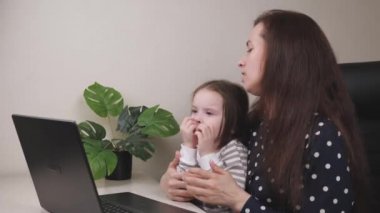 Anne ve küçük bir çocuk internetteki doktor randevusunda video bağlantısı ile, bebek viral grip, koronavirüs salgını, öksürdüğünde izole edilmiş, sovid 19, bilgisayar ekranı ile iletişim kuruyor.