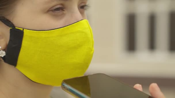 Een jong meisje met een masker is het hebben van plezier praten op een smartphone online en lachen, modern leven van tieners in gadgets, een moderne man communiceert aan de telefoon door middel van een applicatie, het uitspreken van tekst — Stockvideo