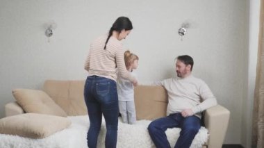 Çocuk evde oynuyor, ebeveynler kanepeye atlıyor, mutlu aile hayatı kavramı, anne baba ve küçük çocuk evde karantinada, baba ve anne günü, kapalı çocuk odasında izin günü.