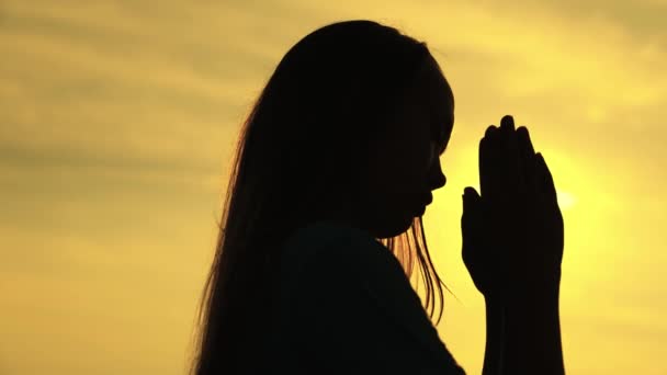 Een moslim meisje bidt in de schittering van de zon aan de hemel, een kleine tiener gelooft in goedheid, vraagt om vergeving uit de hemel, onderwijst een kind in religie, vraagt om goede dingen in het leven, kinderdroom van — Stockvideo