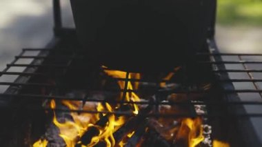 Sıcak bir ateşte tencerede yemek pişirmek, kamp gezisinde yemek tarifi, hafta sonu pikniği, köy hayatı, yanan bir ateşte yemek hayal etmek, mutlu tatil konsepti.