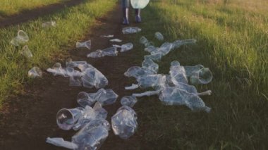 Erkek ve kadın doğada plastik çöp topluyor, yeşil gezegen atığı kirliliği, çevre kirliliği, çevre kirliliği, park caddelerini kirletmemek, gönüllü ekip çalışması yapmamak, bir grup insanın çöplüğü temizlemesi.