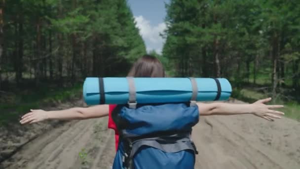 Podróżująca dziewczyna millennium z plecakiem na ramionach podróżuje po parku leśnym, biegając z podniesionymi rękami, by spełnić marzenie, aktywnym stylem życia na wakacjach w wolny dzień — Wideo stockowe
