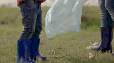 Gönüllü bir ekipteki küçük bir çocuk, yerdeki plastik çöpleri temizleyen bir çocuk, kirlilikten aile temizliği yapan bir kız, bebek dünyanın daha temiz, çevre, takım çalışması, mutlu bir aile olmasına yardım ediyor.