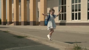 Okul bahçesinde oynayan mutlu küçük bir kız, sırt çantalı küçük bir çocuk, bebek omuzlarında bir okul çantası, eğlenceli bir çocuk ilkokulu, çocukluk hayali, eğlenceli bir okul hayatı