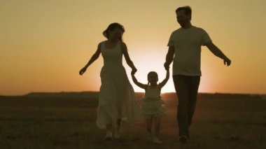 Mutlu anne ve baba tarlada koşar gökyüzünde küçük çocuk günbatımı, neşeli aile, çocukluk hayali ebeveynler, birlikte oyun, çocuklara ilgi, çocuğa anne ve baba sevgisi