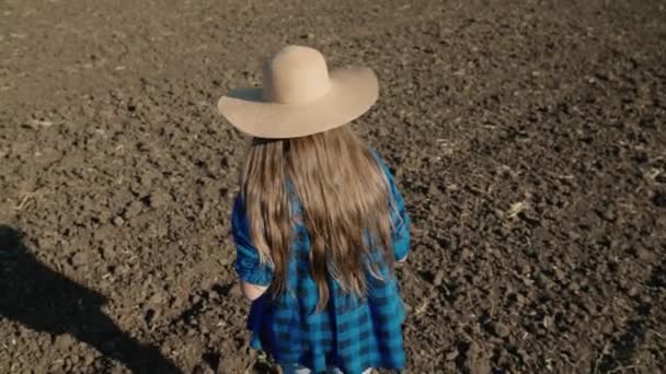 Agriculture, un agriculteur en bottes de caoutchouc marche sur la terre labourée, reposer une parcelle de terre après la récolte, un agronome vérifie le sol tenant une tablette dans sa main, l'agro-industrie des champs dans la — Video