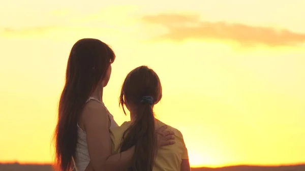 Mother hugs and regrets her daughter against the backdrop of the sunset sky, love children, difficult age of teenager, take care of childs mental health, be attentive and kind, care and compassion — Stock Photo, Image