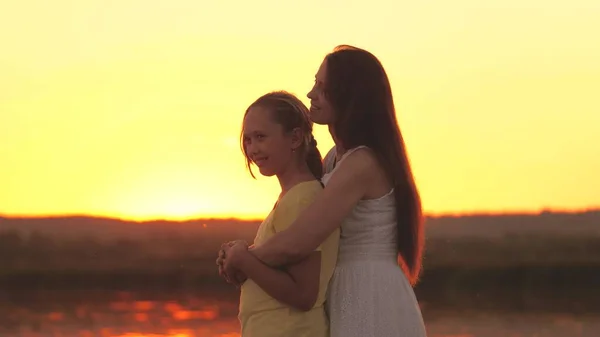 Madre abraza y lamenta a su hija contra el telón de fondo del cielo del atardecer, amar a los niños, edad difícil de adolescente, cuidar de la salud mental de los niños, estar atento y amable, cuidado y compasión —  Fotos de Stock