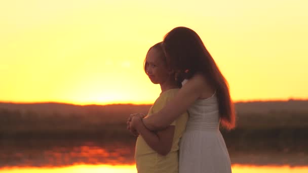 Η μητέρα αγκαλιάζει και λυπάται για την κόρη της στο φόντο του ηλιοβασιλέματος του ουρανού, αγαπά τα παιδιά, δύσκολη ηλικία των εφήβων, φροντίζει τα παιδιά ψυχική υγεία, να είναι προσεκτικοί και το είδος, φροντίδα και συμπόνια — Αρχείο Βίντεο
