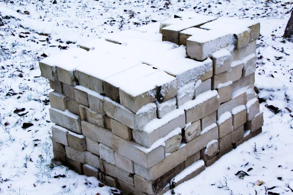 新下的雪砸在建筑材料上 一堆砖 — 图库照片