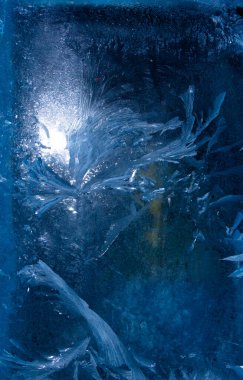 Donmuş penceredeki buz desenleri Noel mucizesinin bir sembolü..