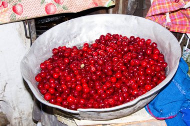 Büyük bir alüminyum kasede taze kirazlar.