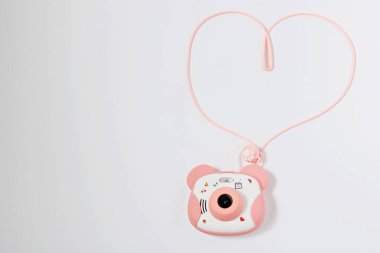 Silikon pembe bir çantada çocukların gerçek kamerası ve beyaz arka planda bir ip..