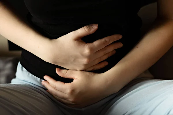 一个女人在肚子痛的时候把她的手放在肚子上 月经抽筋 食物中毒的特写镜头妇女 — 图库照片
