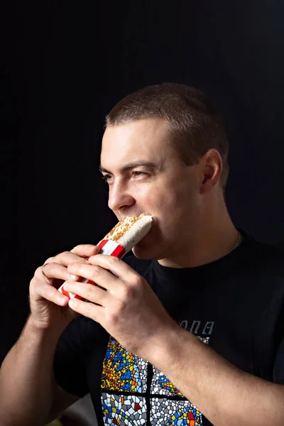 Young hungry man eating fast food, unhealthy food. Diet concept