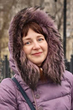 Şehrin arka planında gülümseyen güzel bir kızın portresi. Kış modası, Noel tatili konsepti