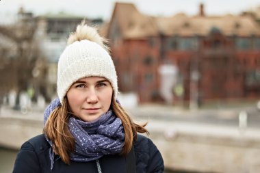 Şehrin arka planında gülümseyen güzel bir kızın portresi. Kış modası, Noel tatili konsepti