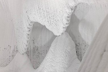 Beyaz kabartmalı buz duvarları ve bir mağarada kar. Soyut dokulu doğal arkaplan