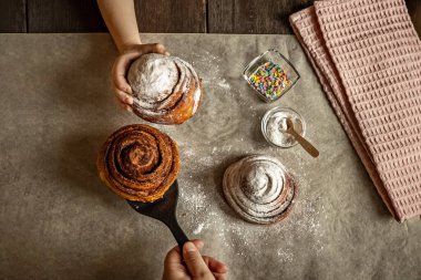 Çocuk eli taze pişmiş tarçınlı çörek alır..