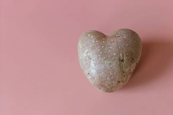 Genetically modified food, heart shaped potatoes on a pink background. Products of modern agriculture and genetic engineering