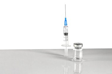 Coronavirus aşısıyla şırınga ve şişe, gri arka planda enjeksiyon şişesi. Önleme, tıbbi konsept, covid-19 aşılama