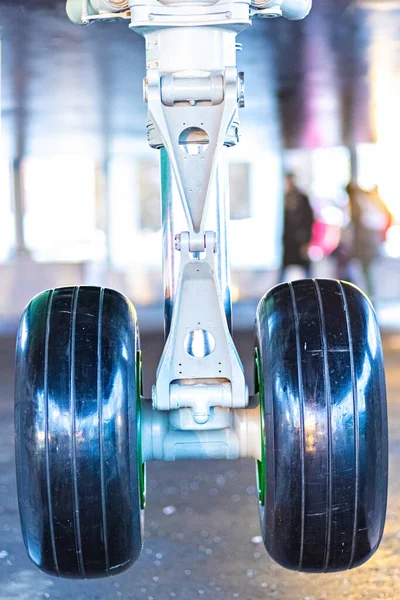 The forward landing gear of a passenger aircraft in the air when landing at the airport