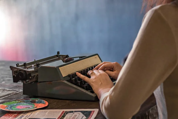 Women\'s hands on the keys of an old typewriter.