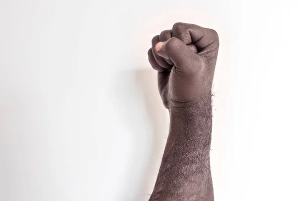 Beyaz arka planda erkek eli yumruğa sıkıştı. Amerika 'daki siyahların hakları için verilen mücadelenin sembolü. Irkçılığa karşı protesto