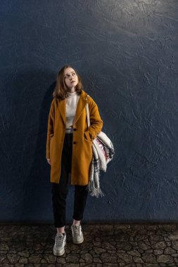 Mavi duvara dayanmış genç bir kızın portresi.