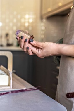 Sabun üreticisi bir kız elinde yeni demlenmiş bir sabun tutuyor. Yemek pişirme süreci. Ev spa 'sı. Alışveriş merkezi işi.